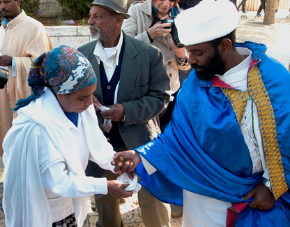 The qessotch distributing handfuls of Jerusalem soil to the worshipers